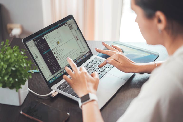 a woman working on her laptop and thinking about how CRM automation enhances efficiency