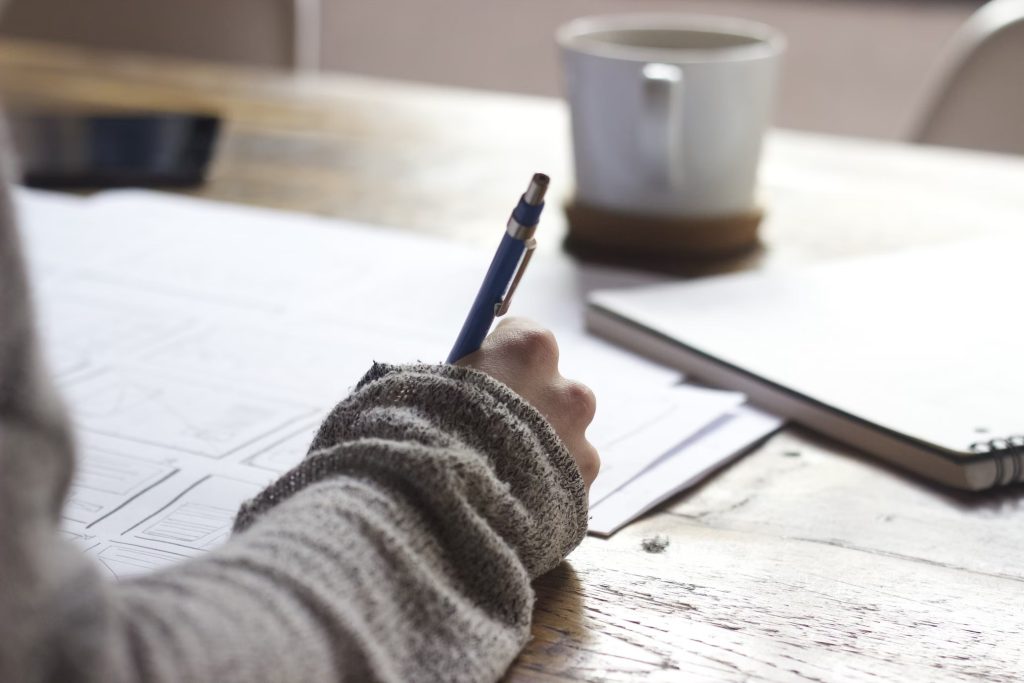A close-up of a person keeping notes with a pen.