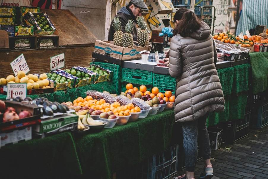 A person shopping in an outdoor fruit market.