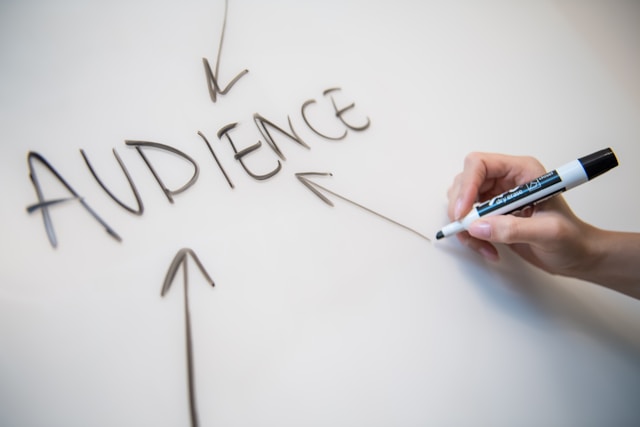 Word Audience on a whiteboard with a person drawing arrows and pointing to it.